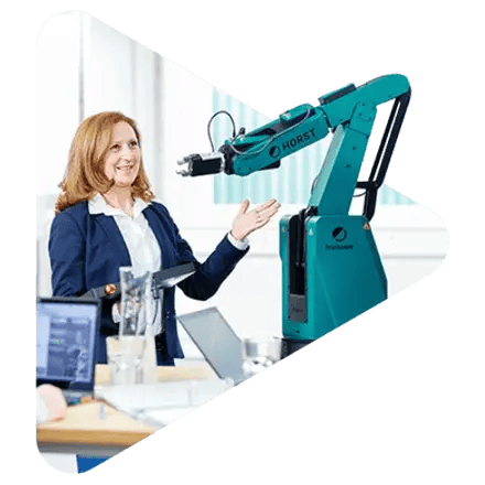A woman in an office presents the robot arm Horst, which is equipped with a gripper.